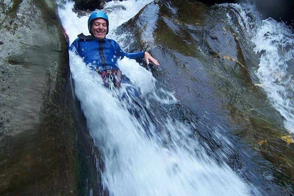 An image of a man canyoning in a mountain river, summer activity with Meribel Bureau des Guides