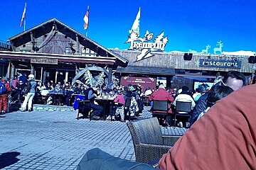 A group of people are sitting outside of a restaurant called le tremplin