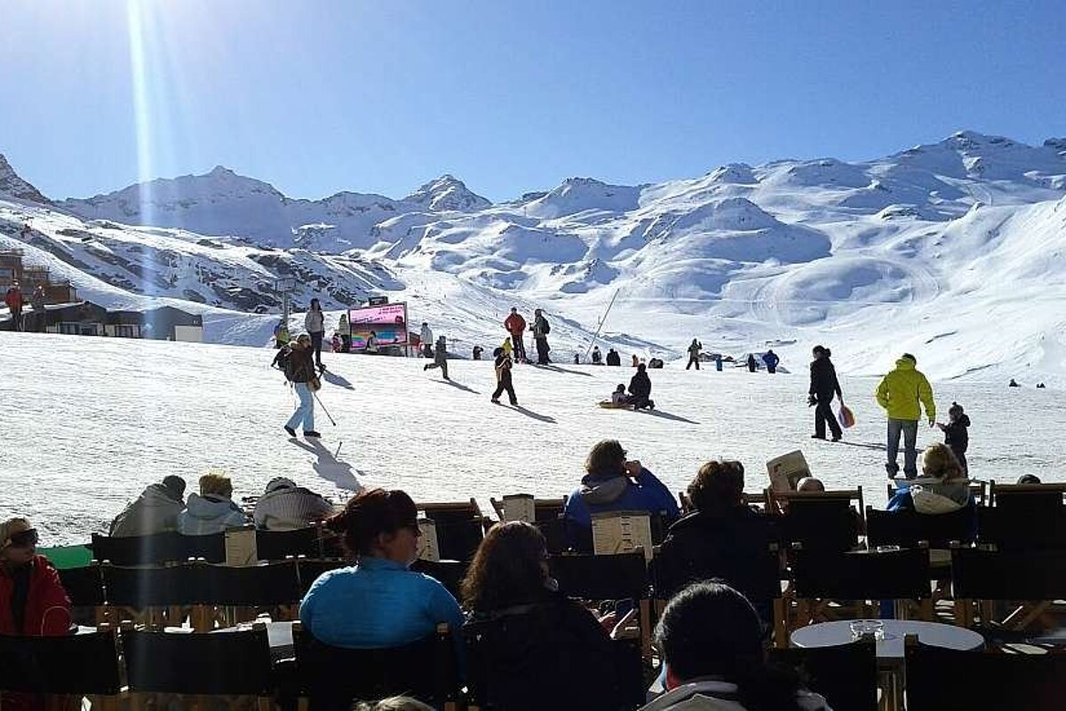 A group of people are sitting in chairs in front of a snowy mountain