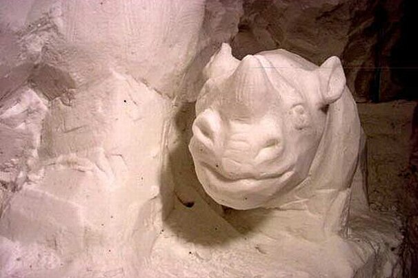 A statue of a rhinoceros carved out of snow in a cave