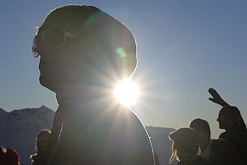 An image of skiers dancing in the sun