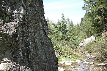 A river runs through a rocky area with trees in the background