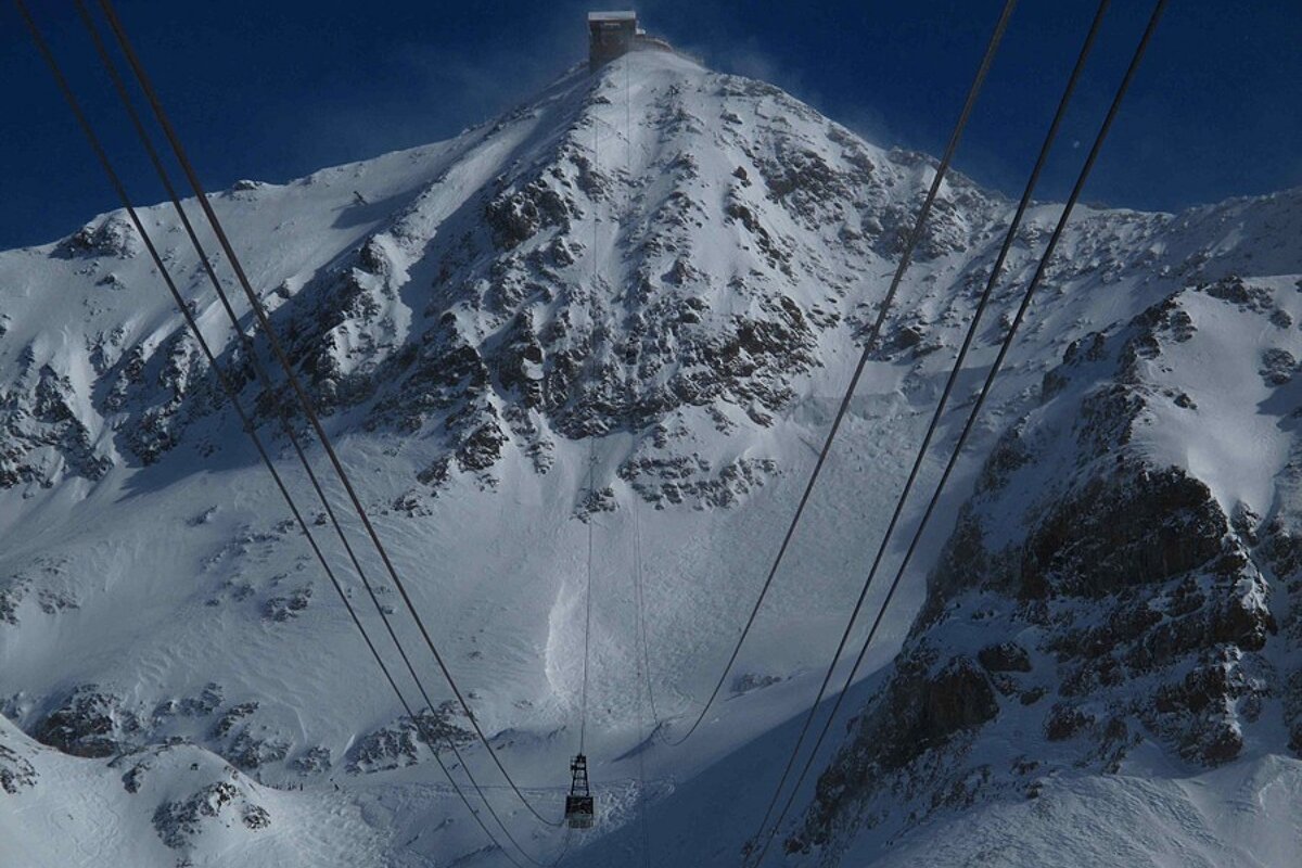 A ski lift going up a snow covered mountain