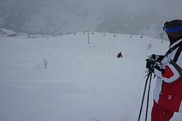skier taking a break to right of piste