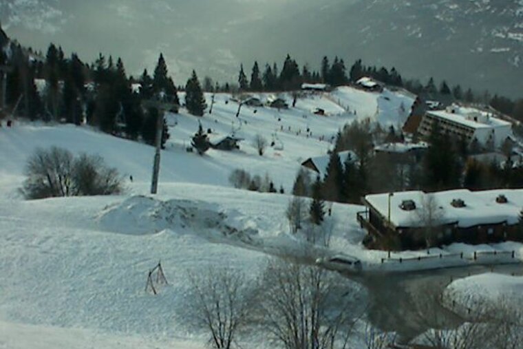 A snowy landscape with a ski resort in the background