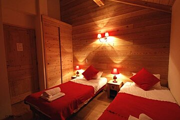 an image of a twin bedroom with lights on at night