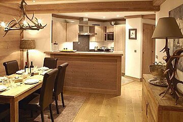 A dining room with a table and chairs and a lamp