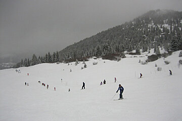 A group of people skiing down a snow covered slope