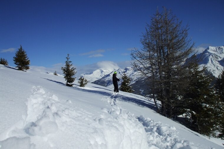 A person standing on top of a snow covered mountain