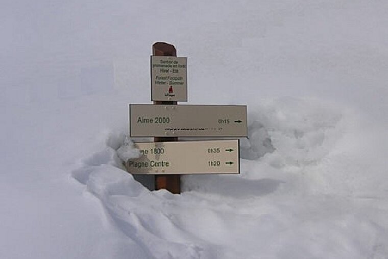 A sign in the snow that says aime 2000 on it