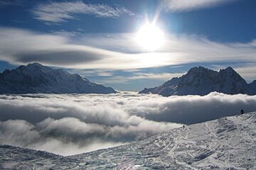 The sun is shining through the clouds over the mountains