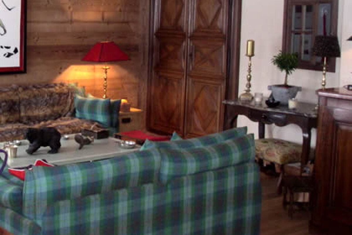 A living room with a couch , table , chairs and a lamp