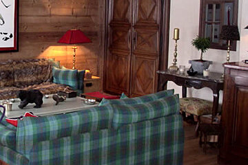 A living room with a couch , table , chairs and a lamp