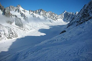 A snowy mountain range with a blue sky in the background