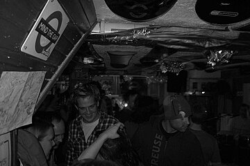 A sign that says mind the gap hangs above a crowd of people