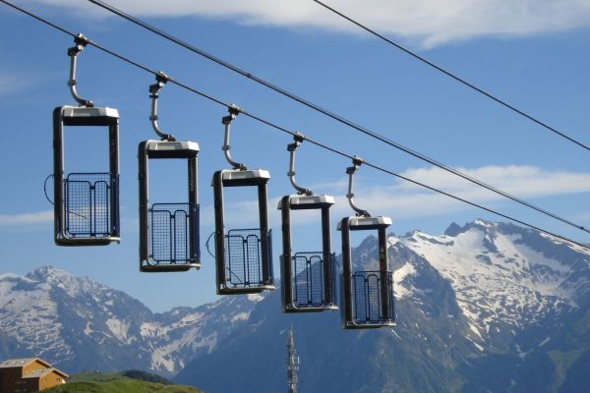 A row of ski lifts with mountains in the background