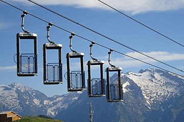 A row of ski lifts with mountains in the background