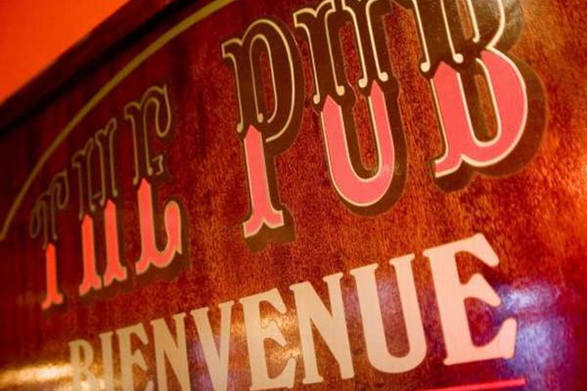 A wooden sign with the words `` the pub bienvenue '' written on it