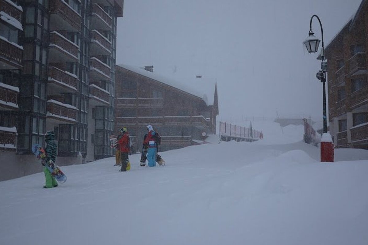 Boarders standing in Val Thorens street in snow