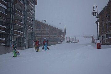 Boarders standing in Val Thorens street in snow