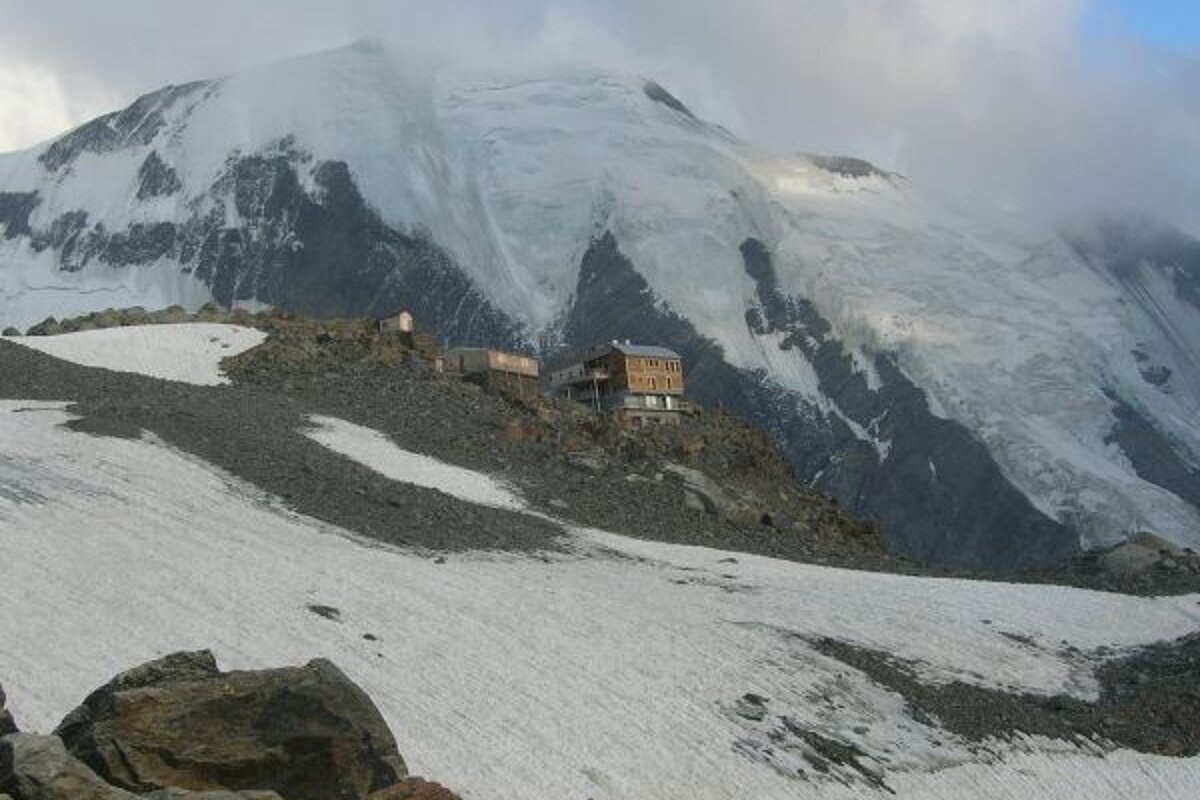 A snowy mountain with a house on top of it