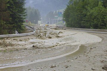 A flooded road with a stop sign in the background
