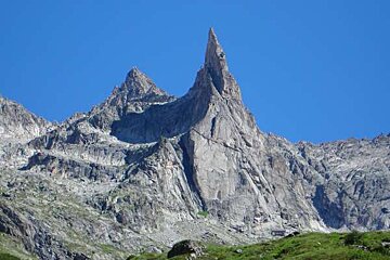A large rocky mountain with a blue sky in the background