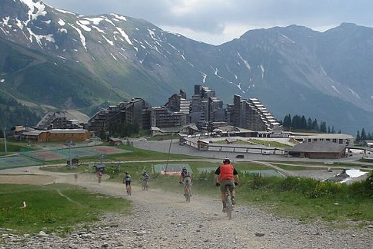 A group of people riding bikes down a dirt road