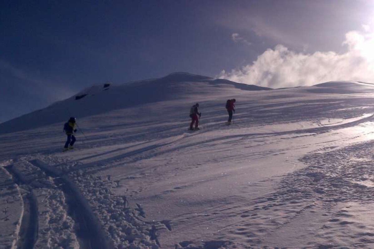 A group of people walking up a snowy hill