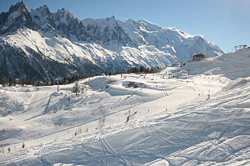 A snowy landscape with mountains in the background