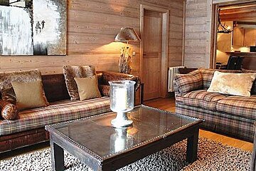 an image of a room with 2 sofas and a coffee table with a glass vase on