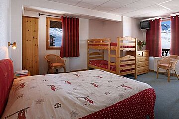 A bedroom with a bunk bed and a bed with skis on it