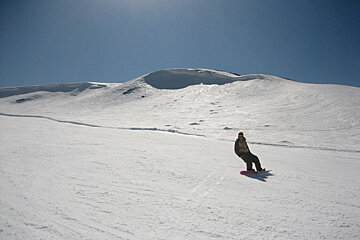 A person riding a snowboard down a snowy hill
