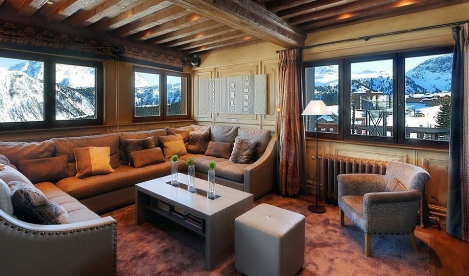 image of a chalet living area with brown sofas and a view of the mountains