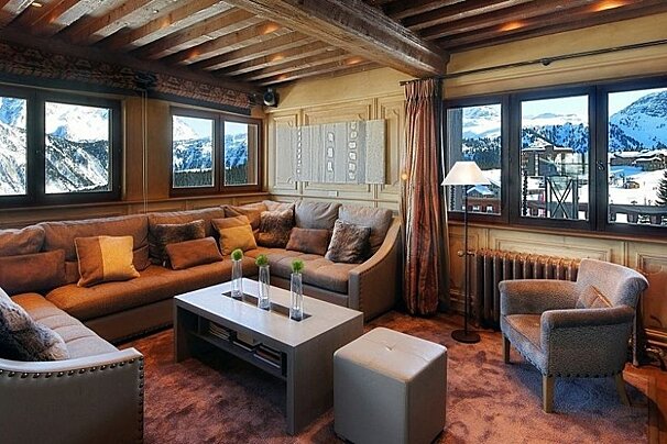 image of a chalet living area with brown sofas and a view of the mountains