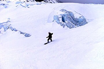 A person riding a snowboard down a snow covered slope