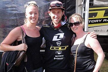 an image of a tall mountain bike racer with 2 fans