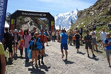 A group of people are gathered in front of an inflatable salomon sign
