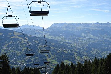 A row of ski lifts with mountains in the background