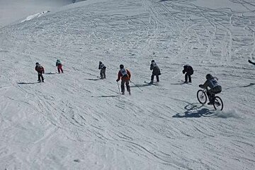 Skier and biker on slope