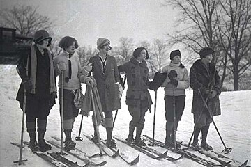 A group of women are standing in the snow on skis