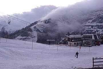 A ski lift is going up a snowy mountain