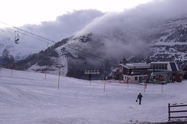 A ski lift is going up a snowy mountain