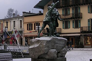 A statue in front of a building that has the word cafe on it