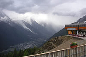 A view of a mountain range with a building in the foreground