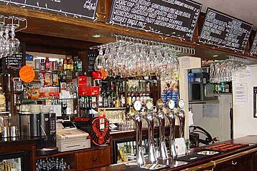 an image of a bar with chalk boards above showing the prices