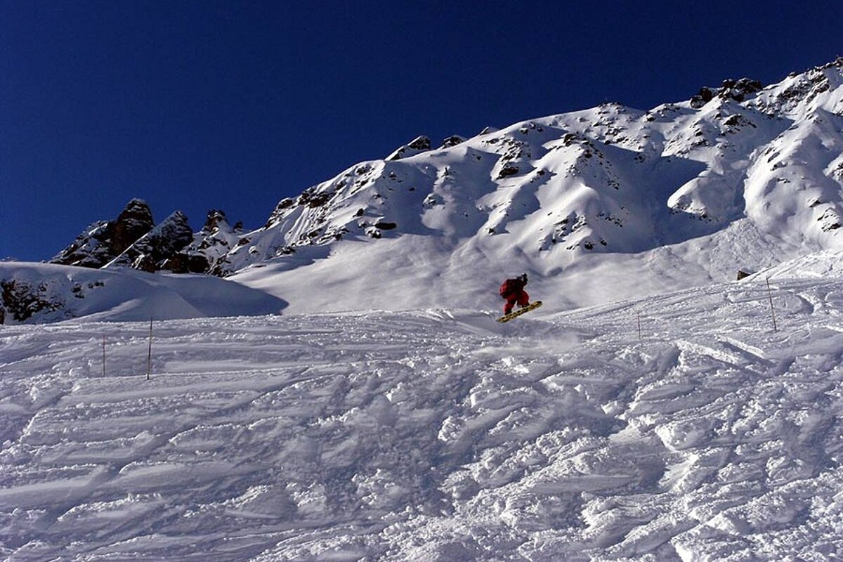 A person riding a snowboard down a snow covered slope