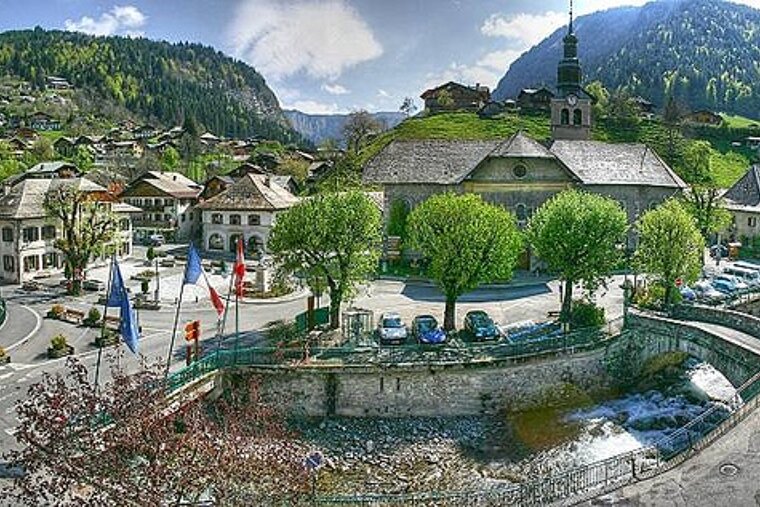 An aerial view of a small town in the mountains with a river running through it