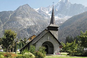 a picture of a church in chamonix with mountains behind