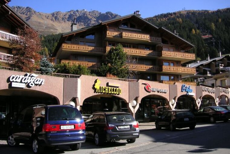 Cars are parked in front of a building that says cardigan